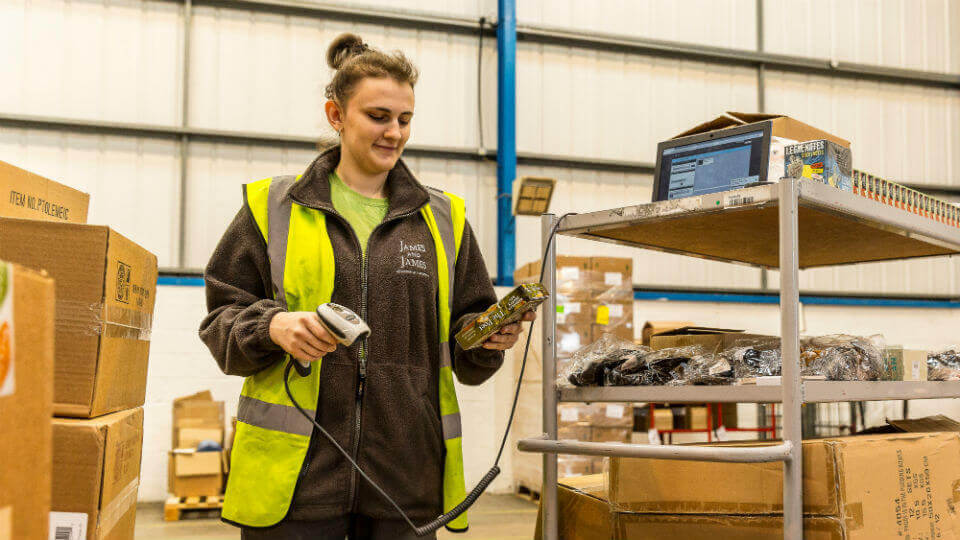 A James and James team member scans a product barcode inside the fulfillment warehouse