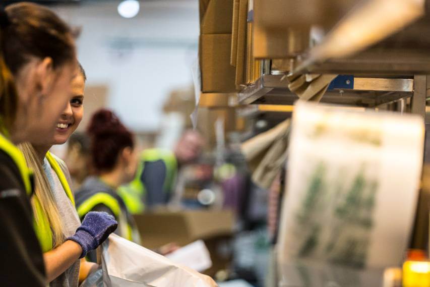 Members of our fulfilment centre team packing parcels as part of our order fulfilment services