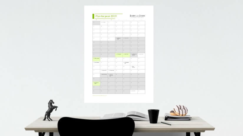The "Plan for Peak" wall planner pinned about a desk