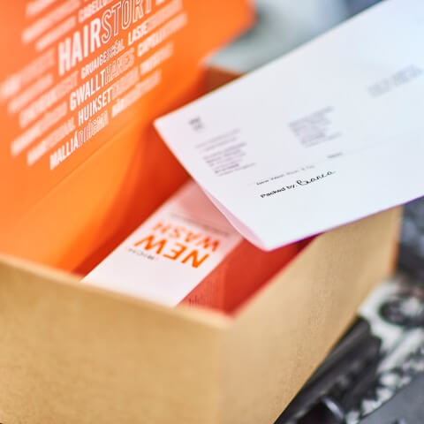 A Hairstory product and packing slip is placed in custom packaging as part of James and James's fulfilment service