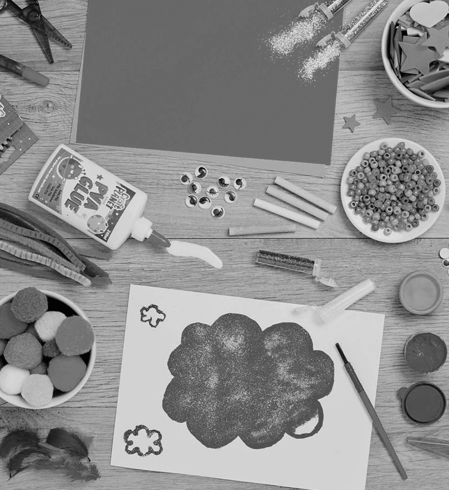 A collection of arts and crafts products laid out on a wooden table shot from above