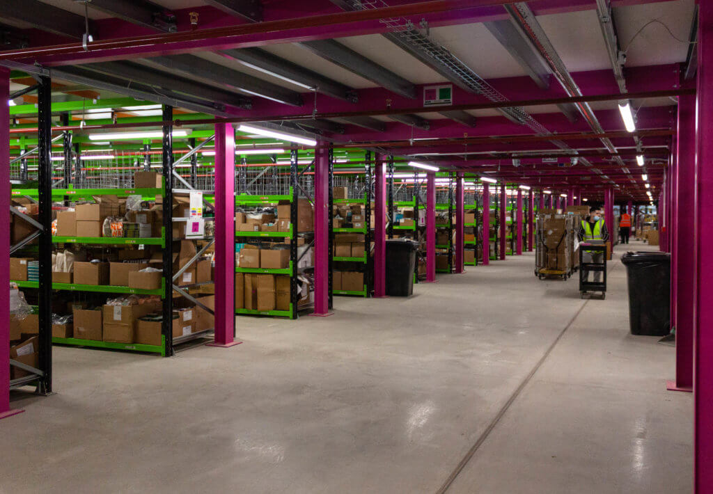 Ground floor of Liberty pick tower with pink and green racking