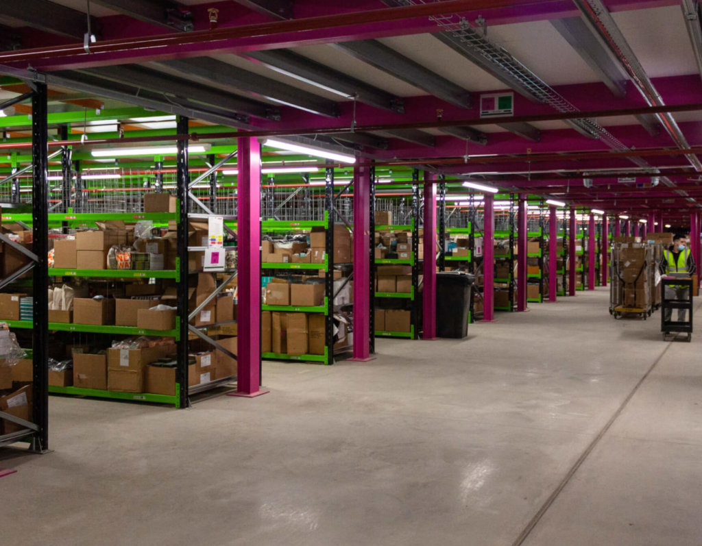 Ground floor of Liberty pick tower with pink and green racking